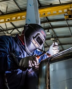 Welder in mask working on project