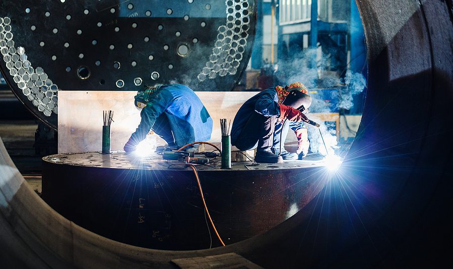 Two welders working on a custom metal fabrication project.