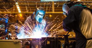 Industrial welder working on a custom metal fabrication project.