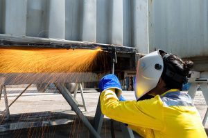 Industry Woker Welding concept - Industry worker with protective mask welding steel to repair container structures manufacture workshop. Worker welding in factory industry.