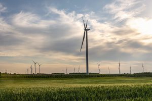 Wind turbine in wheat field in sunset. Sustainable energy. Sustainable electric energy source. Wind turbine in wheat field. Wind turbine in sunset. Electric power plant wind turbine in Serbia. Environmental protection sustainable energy. Wind turbine.