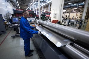Male steel worker using a plate roller machine. 