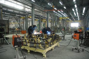 Welders working on a project on a steel platform in an industrial factory. 