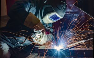 Welder working on a steel project with sparks flying. 