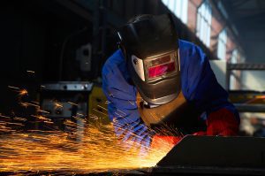 Welder working on a project with sparks flyilng. 