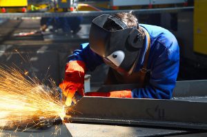 Welder working on a project with sparks spreading. 