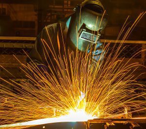 Closeup of a welder working on a project with sparks flying.