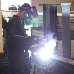 Welder wearing protective gear and working on a project. 